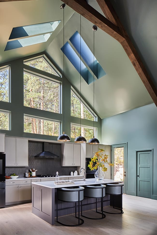 Green kitchen with four skylights and white cabinets